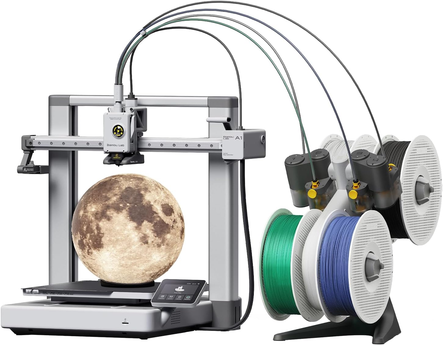 Bambu Lab A1 3D printer beside an AMS lite four-spool holder, with a glowing moon-shaped printed lamp on the build plate.